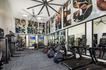 Gym with cardio equipment and posters on the wall